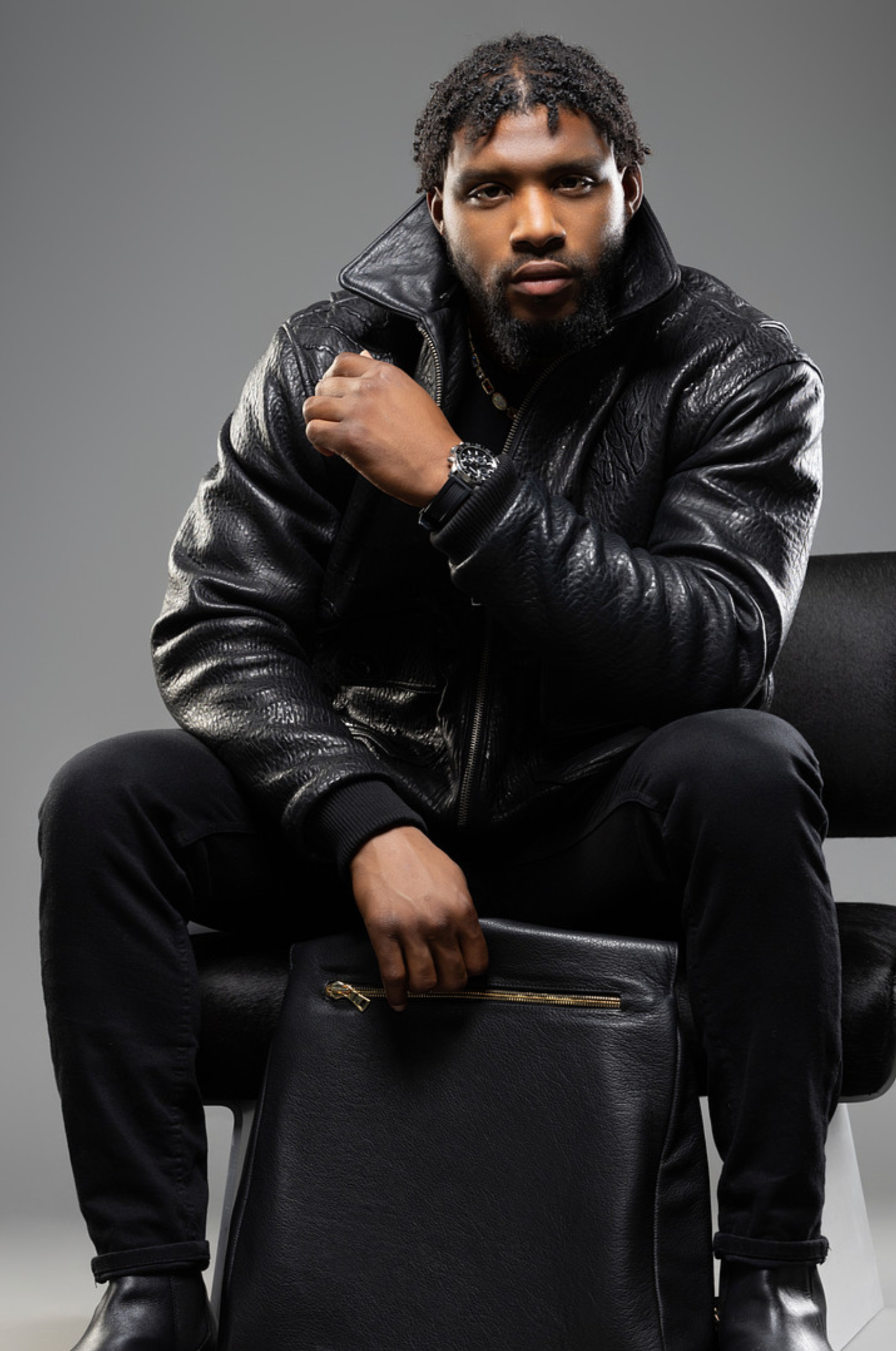 man wearing a SESS RAY black leather jacket and holding a SESS RAY black leather bag